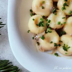 Pyszne kluski śląskie w sosie, posypane szczypiorkiem. Zastanawiasz się, ile gotuje się kluski? Te wyglądają idealnie!