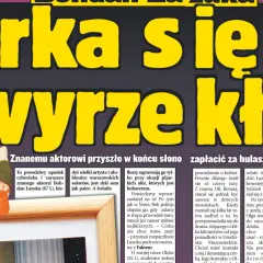 Bohdan Łazuka w swetrze w kratę, z pomarańczowym kubkiem.