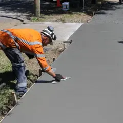 Robotnik wygładza świeży beton. Sprawdź, jaka jest kubik betonu cena, by zaplanować budowę!