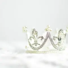 Srebrna korona ozdobiona perłami i kryształkami. Symbolizuje siłę, władzę i piękno, często wybierana jako tatuaż korona znaczenie.