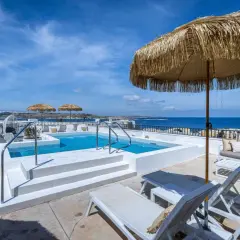 Malta gdzie nocować? Taras z basenem i widokiem na morze, idealne miejsce na relaks.