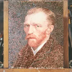 Portret Vincenta van Gogha, słynnego malarza bez ucha, na sztalugach, otoczony pędzlami.