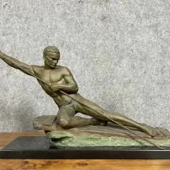 Sculpture d'un athlète en mouvement, tenant une lance. L'œuvre en bronze ou régule, est posée sur un socle en marbre noir.