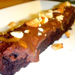 En bit fransk chokladtårta med chokladglasyr och nötter.