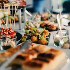 Un apéro dinatoire enceinte, avec des verrines, des brochettes de tomates cerises, des boules de fromage et des tartines.