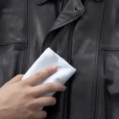 Delikatne czyszczenie kurtki skórzanej białą ściereczką, przywracające jej blask.