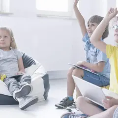Niños participando en juegos en inglés para niños, levantando las manos con entusiasmo.