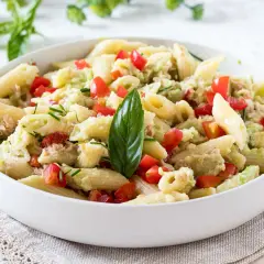 Penne con tonno e avocado, un piatto fresco e colorato con pomodorini e basilico.