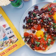 Deux œufs sur le plat, haricots noirs et sauce tomate sur tortillas, inspirés par le livre "Mexican Kitchen" d'Eva Longoria. Un plat de huevos rancheros savoureux.