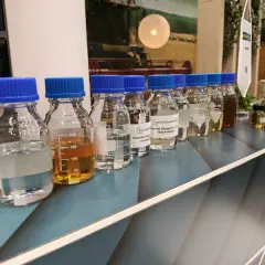 Różne oleje w butelkach, od jasnych po ciemne. Czy można mieszać olej hydrauliczny z przekładniowym? Eksperymenty z płynami.