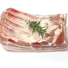 Un morceau de poitrine de porc frais, avec des côtes apparentes et une branche de romarin posée dessus, prêt à être cuisiné.