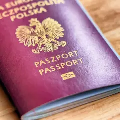 Polski paszport biometryczny z godłem orła i napisem "PASZPORT PASSPORT" na bordowej okładce.