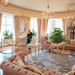 Elegancki salon z różowymi sofami i kryształowymi żyrandolami. Marzenie o noclegu w zamku staje się rzeczywistością.