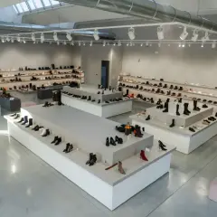 Nowoczesny salon obuwniczy z bogatym asortymentem, od eleganckich szpilek po stylowe botki. Wiele par butów, w tym te z kolekcji agl, czeka na klientów.