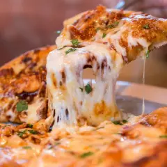 Ein Stück Pizza mit geschmolzenem Käse wird hochgehoben. Die vielen Pizza Kalorien sind es wert!