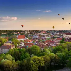 Widok na Wilno z lotu ptaka, z kilkoma balonami na gorące powietrze na niebie.
