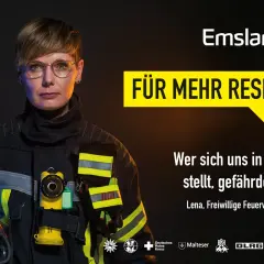 Lena, bei der Feuerwehr, trägt Schutzkleidung und hält einen Helm. Sie steht für Respekt ein.
