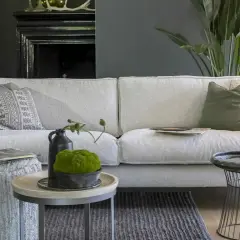 Ein hellgraues Sofa mit verschiedenen Kissen. Die Frage, welche Sofa-Polsterung die beste ist, wird hier stilvoll beantwortet.