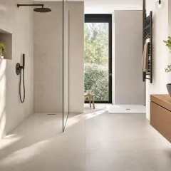 Aménagement douche moderne avec paroi en verre, niche murale et robinetterie noire. Un espace épuré et lumineux.