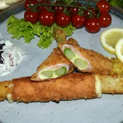 Knuspriges Spargel Cordon Bleu mit Schinken und Käse, serviert mit Dip, Tomaten und Zitrone.