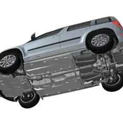 Widok podwozia samochodu z widocznym zawieszeniem hydraulicznym, układem wydechowym i zbiornikami paliwa.