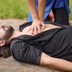 Hände auf die Mitte des Brustkorbs legen und kräftig drücken. So geht Herzdruckmassage, um Leben zu retten.