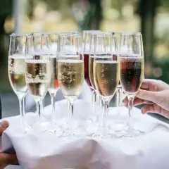 Taca z kieliszkami pełnymi musującego prosecco. Sprawdź aktualne prosecco - ceny i wybierz najlepsze na swoje przyjęcie.