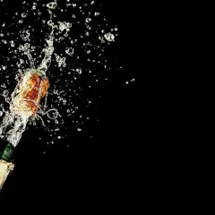 Champagnerkorken spritzt mit Flüssigkeit aus einer Flasche. Perfekt für den Moment, wenn man Champagner lagern und dann genießen möchte.