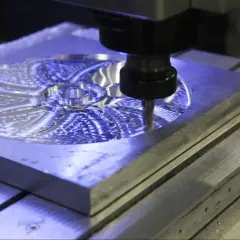 Precyzyjna obróbka CNC tworzy skomplikowany wzór na metalowej płycie.
