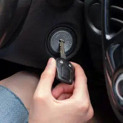Dłoń wkłada kluczyk do stacyjki. To pokazuje, jak działa immobilizer, zabezpieczając auto przed kradzieżą.