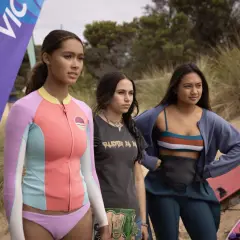 Drei junge Frauen stehen am Strand, bereit für die Wellen. Savannah La Rain und ihre Freundinnen warten auf den perfekten Surf.