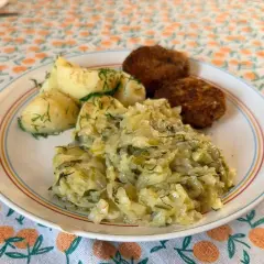 Młoda kapusta z koperkiem, przepis babci, podana z ziemniakami i kotlecikami. Pyszny, domowy obiad.
