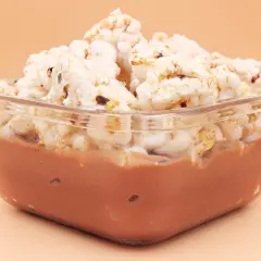 Pudding ryżowy fit w szklanej miseczce, przykryty chrupkami ryżowymi. Idealny na lekki deser.