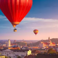 Widok na Wilno z lotu ptaka. Dwa balony unoszą się nad miastem o zachodzie słońca, oferując niezapomniane wrażenia z podróży "Wilno w jeden dzień".