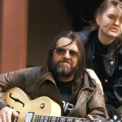 Grażyna Dramowicz biografia: muzyk z gitarą i młoda kobieta w skórzanej kurtce.