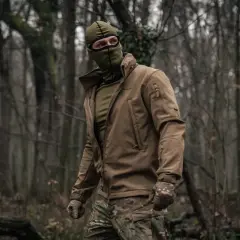 Mężczyzna w lesie, ubrany w kurtkę i maskę, nosi bieliznę termoaktywną Helikon.