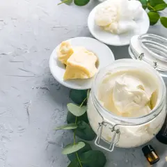 Zutaten für **Body Butter selber machen**: Kakaobutter, Sheabutter, Kokosöl und ätherische Öle. Cremige Textur in einem Glasbehälter.