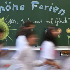 Schöne Ferien! Kinder eilen an einer Tafel vorbei, auf der Sonne, Blumen und ein Herz gemalt sind. Endlich sind die Sommerferien da!