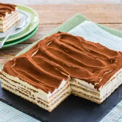 Un invitante tiramisù con oro Saiwa, stratificato e cosparso di cacao, pronto per essere gustato.
