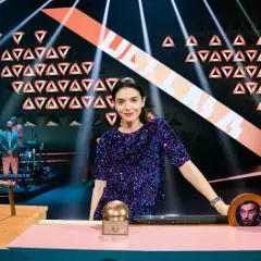 Eine Frau in Glitzerkleid steht im Rampenlicht, während eine Band im Hintergrund spielt. Wer stiehlt mir die Show?