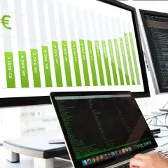 Balkendiagramm zeigt steigende Gehälter für Informatiker, von 37.900 € bis über 50.000 €. Ein Laptop mit Code ist im Vordergrund zu sehen.