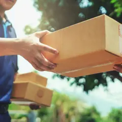 Ein Lieferant übergibt ein Paket. Hoffentlich ist das Paket angekommen und nicht verloren gegangen.