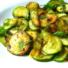 Zucchine alla scapece ricetta napoletana: fette di zucchine fritte e marinate con menta fresca, un contorno saporito e profumato.