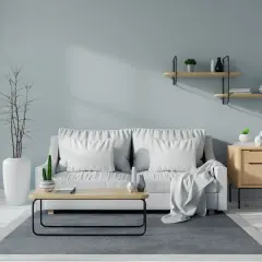 Soggiorno moderno con divano bianco, tavolino in legno e pareti color carta da zucchero.