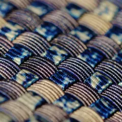 Gros plan sur un tissu intelligent aux motifs bleus et blancs entrelacés, révélant une texture complexe et des fils brillants.
