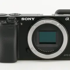 Czarny aparat Sony a6000, gotowy do testów. Widoczny obiektyw E-mount i sensor APS-C.
