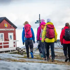 Vandringsgrupp närmar sig STF Sylarnas fjällstation. Vackert höstlandskap med molnig himmel.