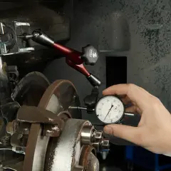 Mechanik mierzy bicie tarczy hamulcowej, by wyeliminować drgania przy hamowaniu z dużej prędkości.