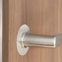 Drewniane drzwi wewnętrzne z nowoczesnym, metalowym uchwytem i dyskretnym zamkiem magnetycznym.