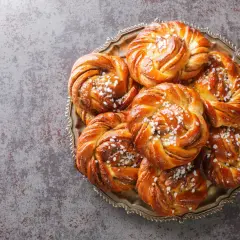 En bricka med nybakade kanelbullar, perfekta att baka i varmluftsugn. Strösslade med pärlsocker.